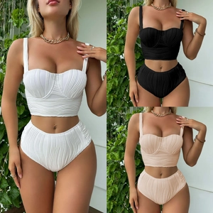 Detail of high-waisted bikini sets in white black and beige with wavy textured fabric
