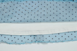 Détail de l'ourlet en tulle bleu clair à pois noirs et bords volantés sur une robe