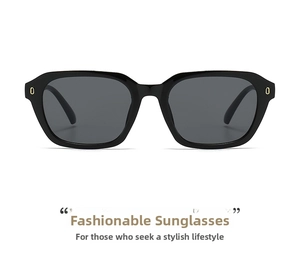 Close-up of black aviator sunglasses featuring gold rivet details and dark grey lenses