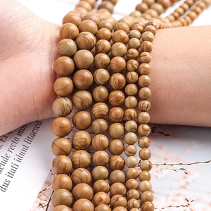 Natural yellow wooden texture stone beads bracelets in various sizes on wrist