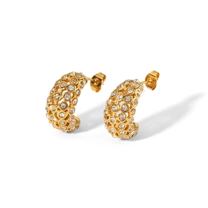 Detail of gold C-shaped hollow earrings with clear pavé crystals on a white background