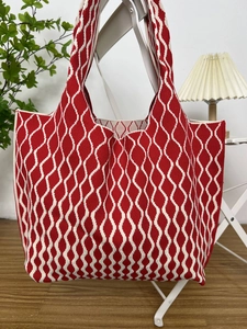 Detail of red and white wave pattern knit tote bag showing soft texture and spacious design