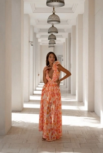 Detail of floral chiffon maxi dress featuring deep V-neck, ruffles, and waist cut-out