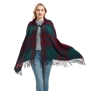 Detail of red and green tartan plaid hooded poncho with decorative fringe tassels