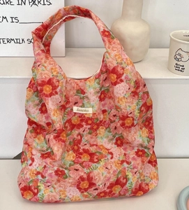 Detail of floral canvas tote bag with woven logo label and colorful flower pattern