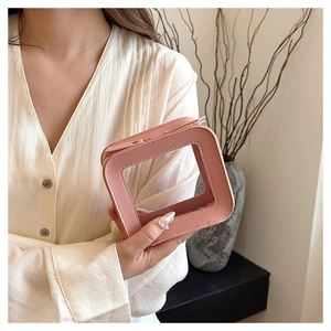 Detail view of a pink transparent cosmetic bag with sleek square design for daily makeup storage.