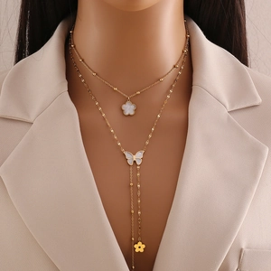 Double-layered gold necklace featuring white mother of pearl clover and butterfly pendants