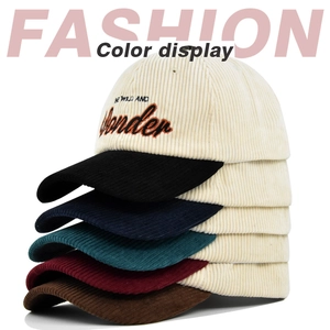 Detailed view of stacked corduroy baseball caps with colorful brims and WONDER embroidery