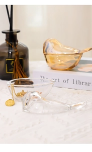 Detailed view of bird-shaped glass jewelry jars in clear and amber tones on a table