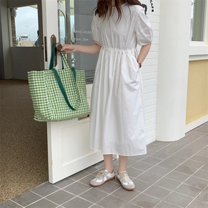 Street style shot of a white short-sleeve high-waist midi dress with a natural fabric texture