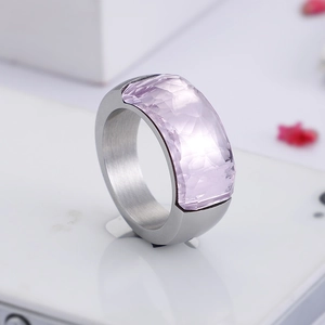 Macro shot of silver titanium ring with faceted light purple gemstone on white surface