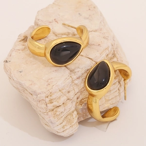 Water-drop shaped cat eye stone C-shaped gold hoop earrings on natural stone