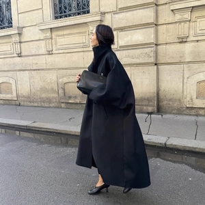 Manteau long noir élégant avec col montant et coupe oversize minimaliste chic