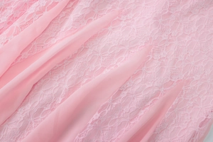 Detail view of pink lace and chiffon stitching with intricate floral textures on dress