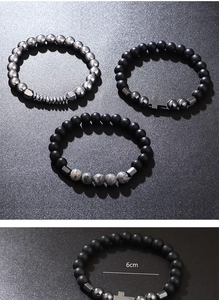 Detail view of hematite stretch bracelets with cross charm and 6cm inner diameter size