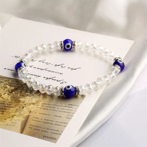 Macro detail of elastic beaded bracelet with blue evil eye beads and crystal spacers