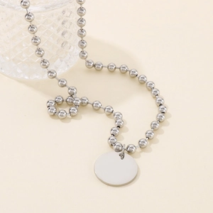 Détail du collier à billes argenté avec un pendentif disque rond poli à graver