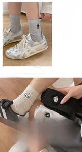 Detail of cute cat embroidery and speckled knit texture on these mid-calf socks