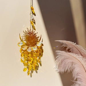 Detailed sun and moon suncatcher with crystals casting rainbow light patterns