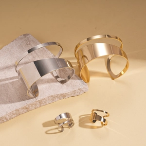 Two-piece set of irregular open metal bangles and rings in polished gold and silver finish