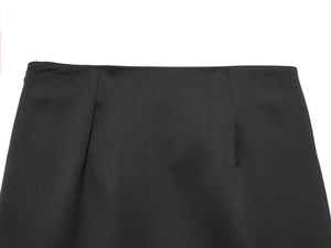 Detailansicht der schwarzen Satin-Rock-Taille mit feinen Nähten und glänzender Textur