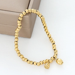 Detailansicht eines goldenen Perlenarmbands mit Lotus- und Knospenanhängern