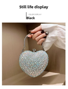 Detail of heart-shaped black evening bag featuring iridescent AB rhinestones and metal handle