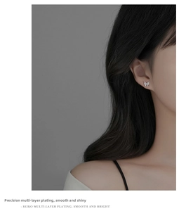 Close-up of s999 sterling silver lava butterfly stud earrings worn on a female earlobe
