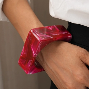 Detail of chunky square red marble resin bangle on wrist with minimalist modern aesthetic