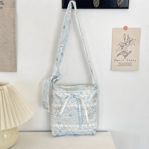 Light blue lace crossbody bag with pink ribbon bows and floral bear pattern detail