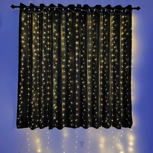 Detail showing warm white LED curtain string lights hanging on a black background