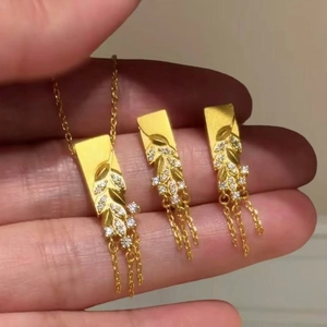 Gold plated wheat fringe necklace and earring set with sparkling zircon stones in hand