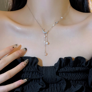 Detail of silver moon tassel necklace with pearls and crystals on a model neck