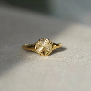 Dettaglio di un anello a sigillo placcato oro 18K con elegante trama a motivo solare