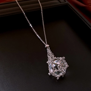 Close-up of a silver mesh globe pendant necklace with sparkling zircon crystal details