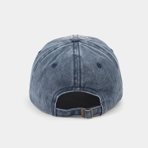 Detail of adjustable bronze metal buckle on vintage washed denim baseball cap back