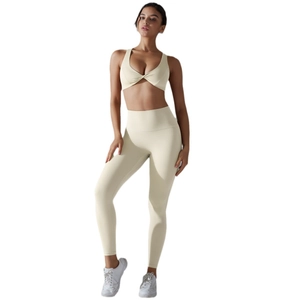 Two-piece solid color yoga set with twist-front sports bra and high waist leggings