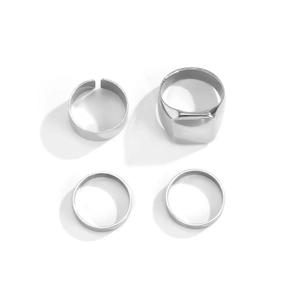 Set of four silver street fashion rings including signet and band styles on white background