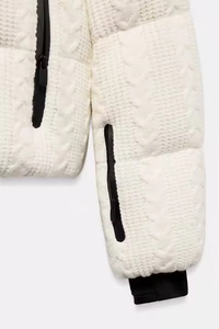 Close-up of cable knit texture and black contrast zipper on white winter ski suit