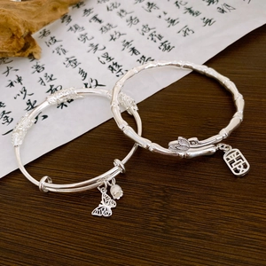 Detail view of bamboo texture silver bracelet with Ping'an pendant and butterfly charm