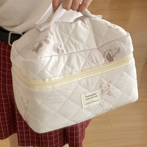 Close-up of quilted cotton cosmetic bag with cute dog prints and metal zipper detail