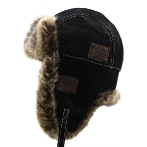 Close-up of black faux leather aviator hat with warm brown faux fur lining and side patch