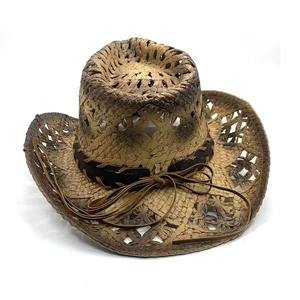 Close-up of western straw cowboy hat with hollow weave texture and brown decorative band