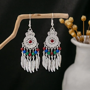 Detail of Bohemian ethnic tassel earrings with turquoise beads and silver feathers