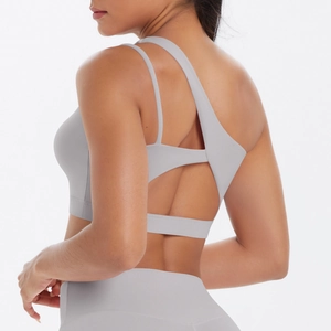 Detail of light grey sports bra showing asymmetric shoulder straps and cutout back design