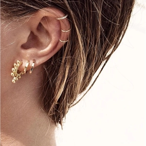 Fashionable gold hoop earrings set with rhinestones and ear clips shown on model