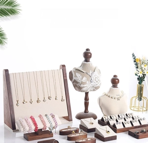 Detail view of walnut wood jewelry stand set with fabric necklace and ring displays