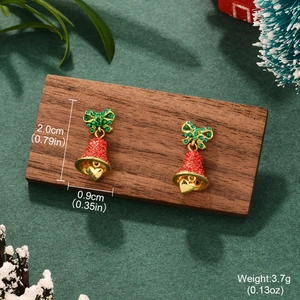 Christmas bell earrings with red and green zircon bow on a festive holiday background