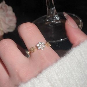 Detail of elegant gold-plated open ring featuring zircon flower and pearl accents