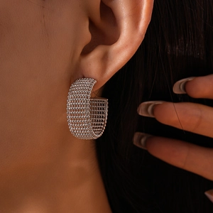 Close-up of geometric mesh silver hoop earrings with textured bead pattern on model